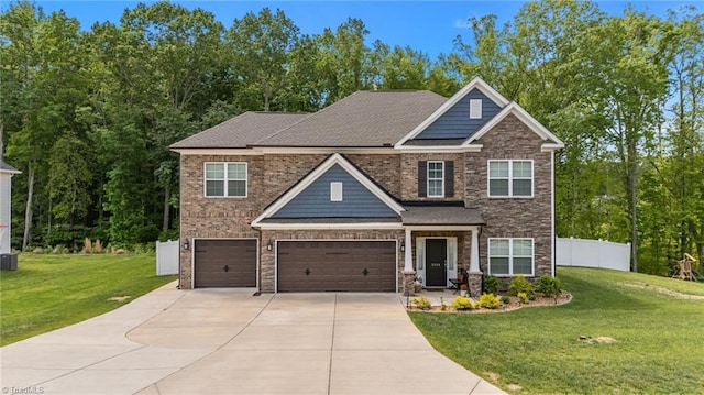 craftsman house with an attached garage, a front lawn, fence, and concrete driveway