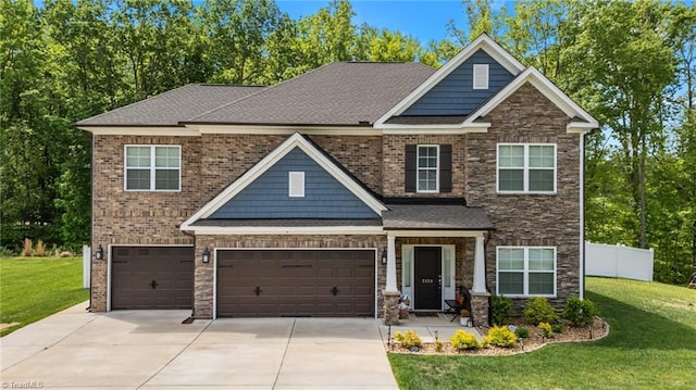 craftsman-style house featuring fence, an attached garage, driveway, and a front lawn