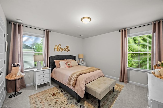 bedroom with baseboards and light carpet