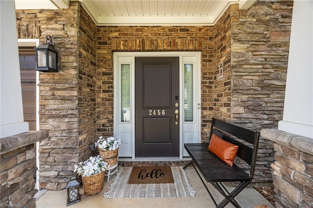 doorway to property featuring brick siding and stone siding