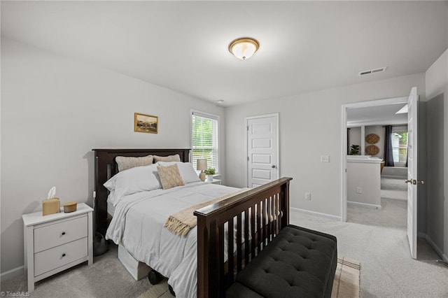 carpeted bedroom featuring baseboards and visible vents