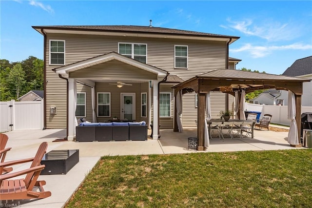 back of property featuring a ceiling fan, a patio area, a gazebo, an outdoor hangout area, and a yard