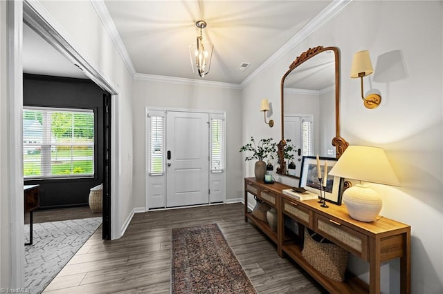 foyer with visible vents, ornamental molding, and wood finished floors