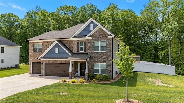 craftsman-style house featuring fence, concrete driveway, a front yard, and stone siding