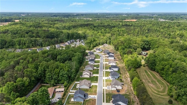 bird's eye view featuring a residential view and a wooded view