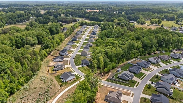 bird's eye view featuring a wooded view and a residential view