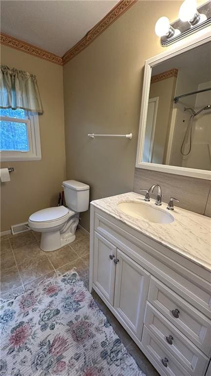 bathroom featuring vanity, tile patterned floors, toilet, and walk in shower