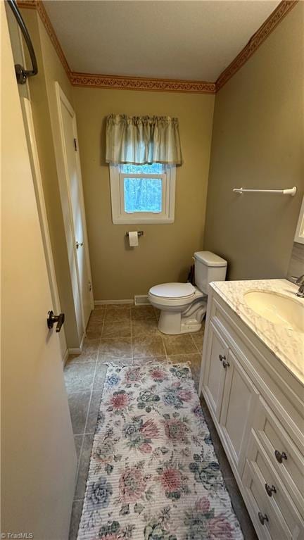 bathroom with vanity, ornamental molding, and toilet