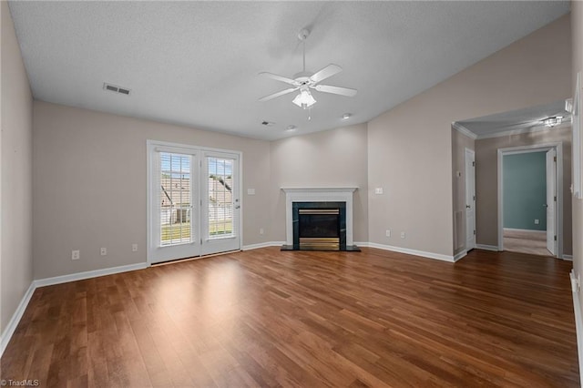 unfurnished living room with visible vents, baseboards, a ceiling fan, dark wood-style floors, and a glass covered fireplace