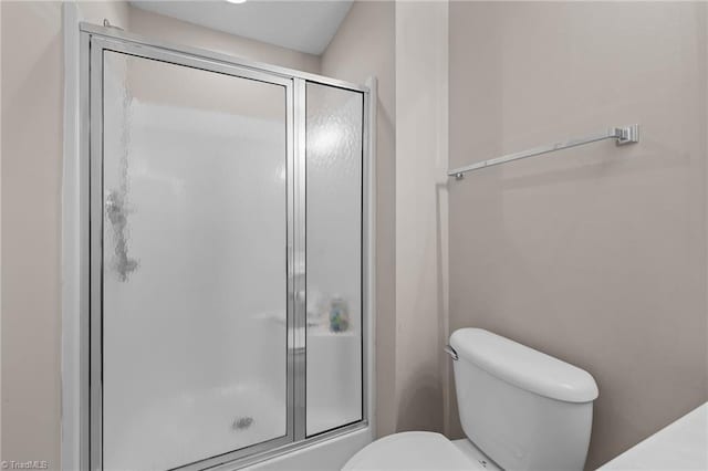 bathroom featuring a shower stall and toilet