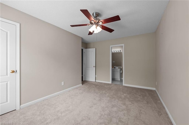 unfurnished bedroom featuring baseboards, connected bathroom, a ceiling fan, and light colored carpet