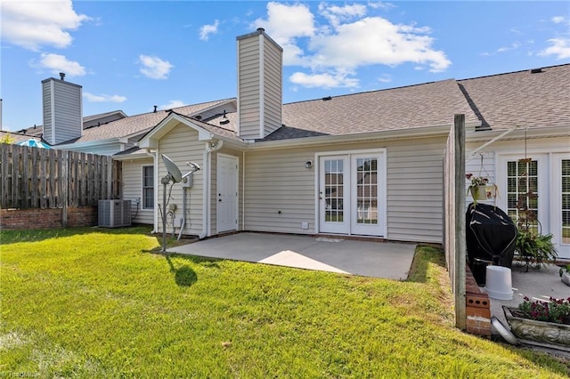 back of property with a patio, a chimney, fence, cooling unit, and a yard