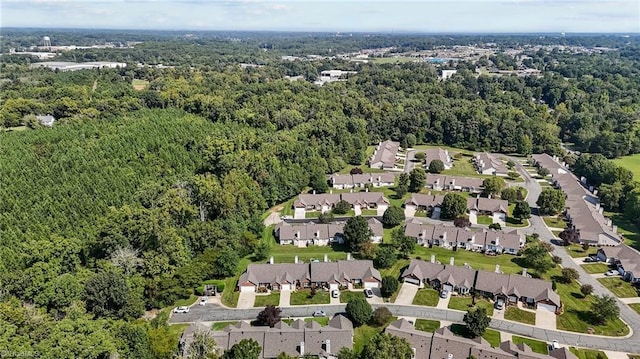 drone / aerial view featuring a residential view and a view of trees