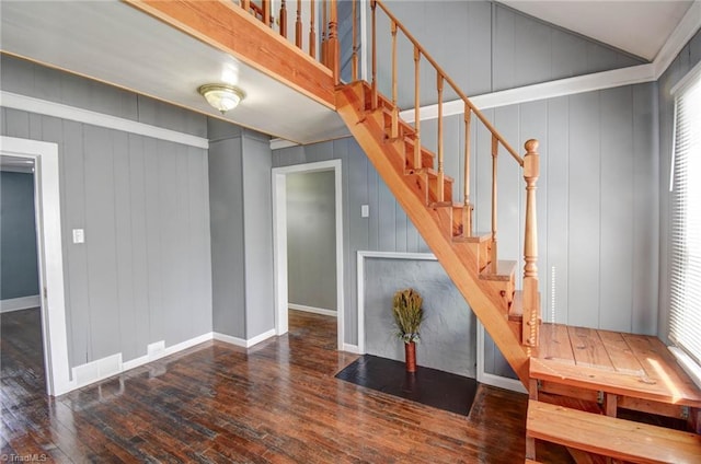 stairs with vaulted ceiling, hardwood / wood-style flooring, and baseboards