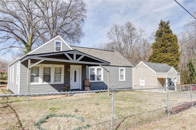 bungalow featuring a front yard, roof with shingles, and fence