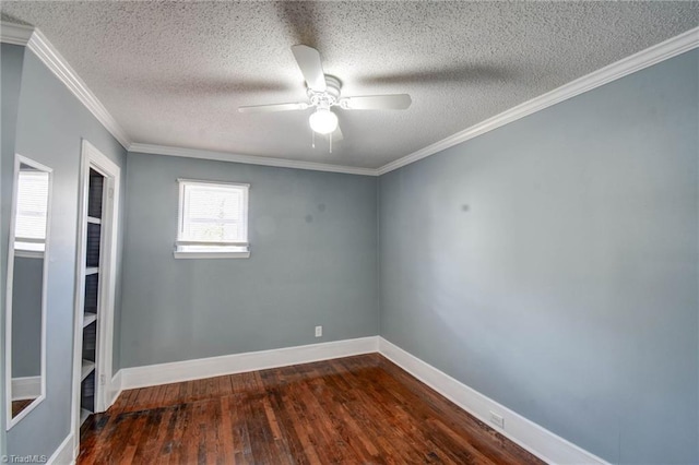 empty room with dark wood-style floors, ceiling fan, baseboards, and crown molding