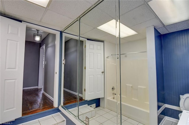 full bath with tile patterned flooring, shower / tub combination, a paneled ceiling, and toilet