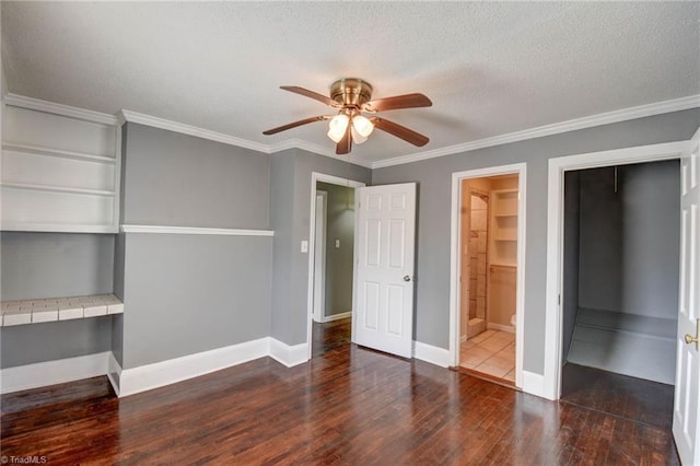 unfurnished bedroom with a textured ceiling, ceiling fan, wood finished floors, baseboards, and crown molding