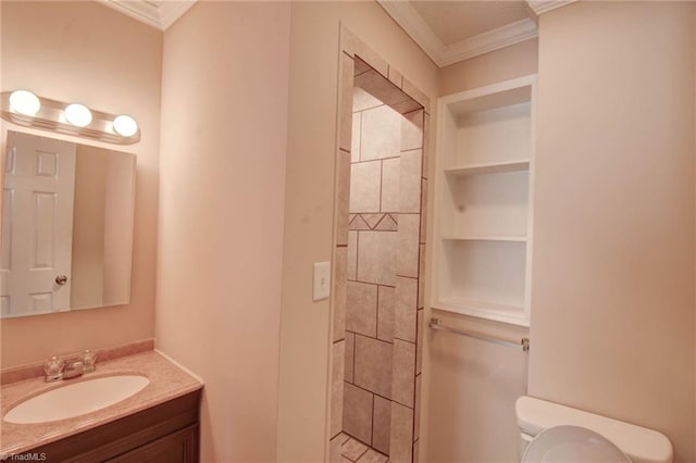 bathroom featuring ornamental molding, a tile shower, vanity, and toilet