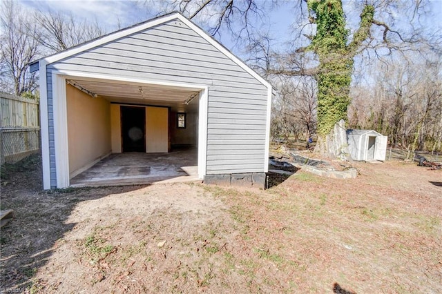 garage featuring a shed and fence