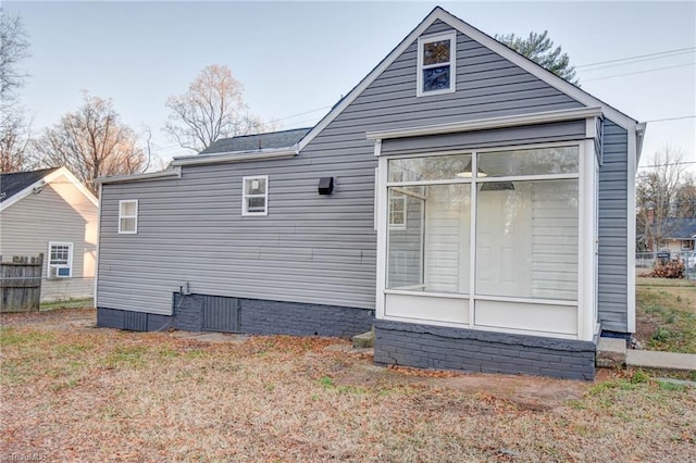 back of property with fence and a sunroom