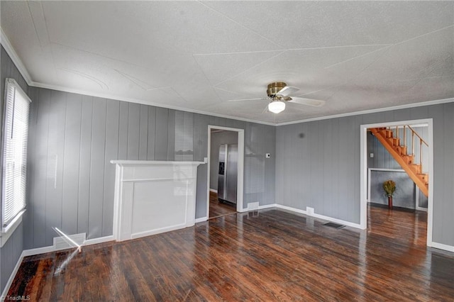 empty room with stairs, visible vents, crown molding, and wood finished floors