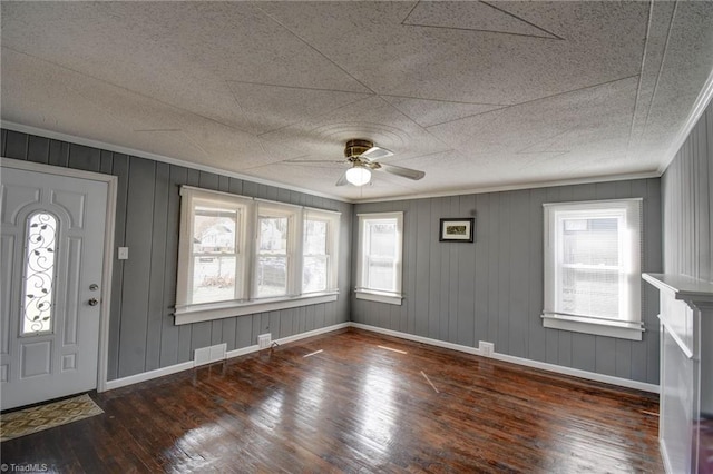 foyer entrance with wood-type flooring, visible vents, crown molding, and baseboards