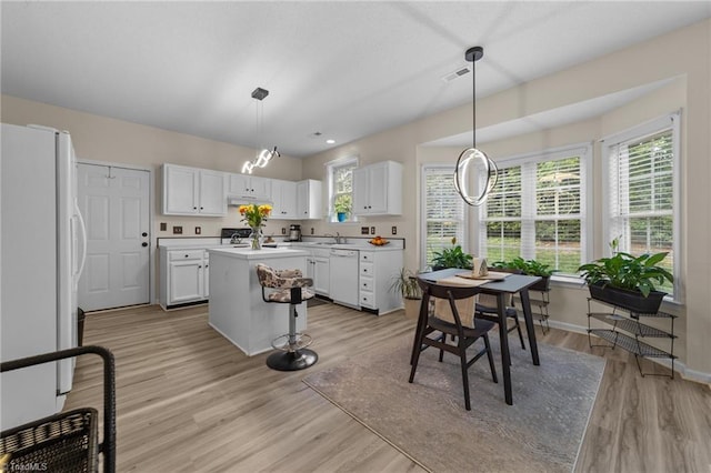 900 Biloxi Ave, Kernersville, NC 27284 - kitchen with white appliances, white cabinetry, a kitchen island, light wood-style floors, and light countertops
