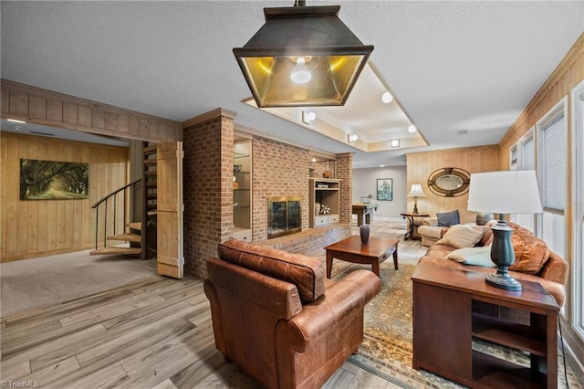 3715 Bentbrook Dr, High Point, NC 27265 - living area with wood finished floors, wood walls, stairs, a textured ceiling, and a fireplace