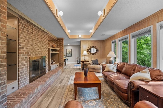 3715 Bentbrook Dr, High Point, NC 27265 - living room with wood-type flooring, a tray ceiling, built in shelves, a fireplace, and wood walls