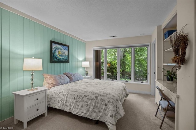3715 Bentbrook Dr, High Point, NC 27265 - bedroom featuring a textured ceiling, carpet flooring, and wood walls
