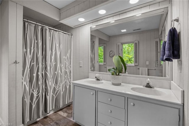 3715 Bentbrook Dr, High Point, NC 27265 - bathroom with double vanity, wood finished floors, a shower with curtain, and wooden walls