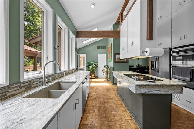3715 Bentbrook Dr, High Point, NC 27265 - kitchen featuring lofted ceiling, plenty of natural light, backsplash, stainless steel appliances, and a kitchen island