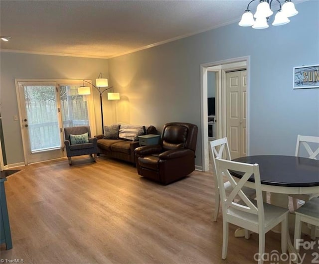 living room with hardwood / wood-style floors, crown molding, and a notable chandelier