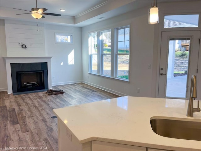 kitchen featuring light countertops, a wealth of natural light, a sink, and decorative light fixtures