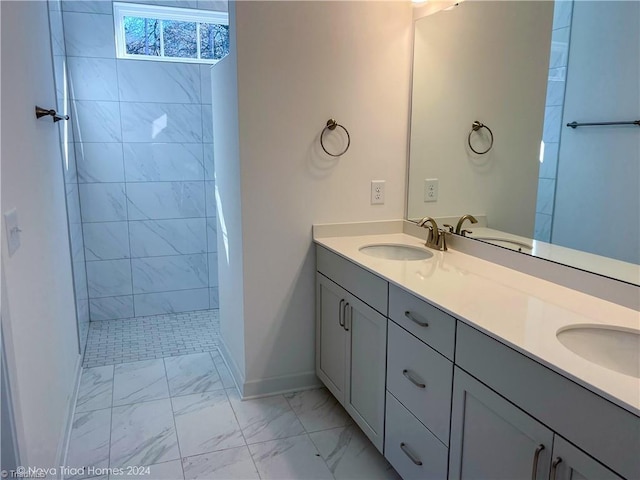 bathroom with marble finish floor, a sink, baseboards, and double vanity