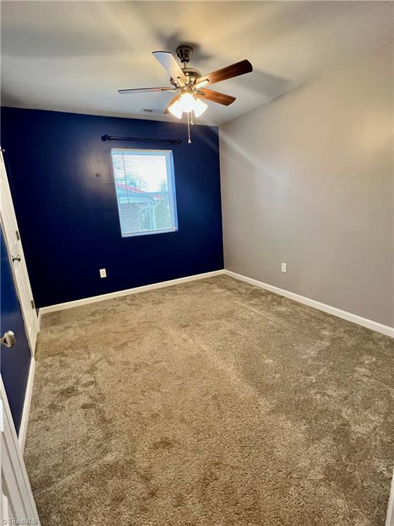 spare room with ceiling fan and carpet floors