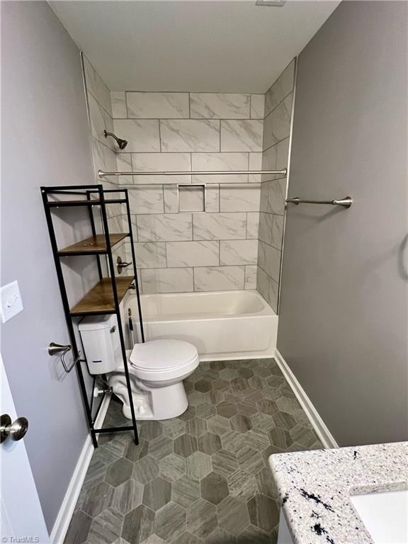 full bathroom featuring vanity, toilet, and tiled shower / bath