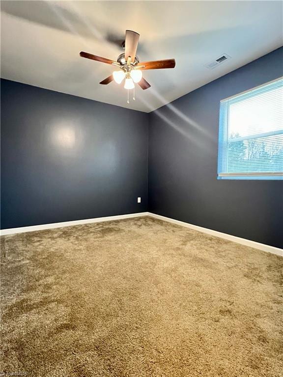 carpeted spare room with ceiling fan