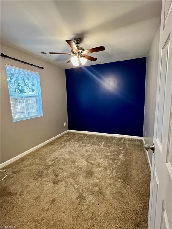 carpeted empty room with ceiling fan