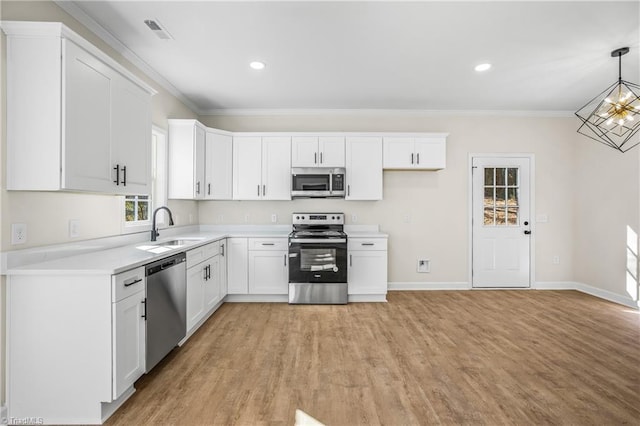 kitchen featuring white cabinetry, appliances with stainless steel finishes, pendant lighting, and light countertops