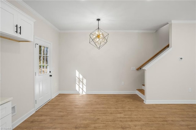 foyer entrance with baseboards, stairway, light wood-style flooring, and crown molding