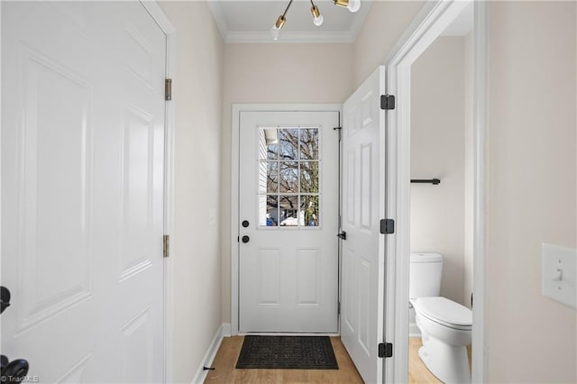 entryway with baseboards, crown molding, and light wood finished floors