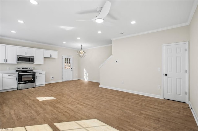 kitchen featuring appliances with stainless steel finishes, white cabinets, light countertops, and open floor plan