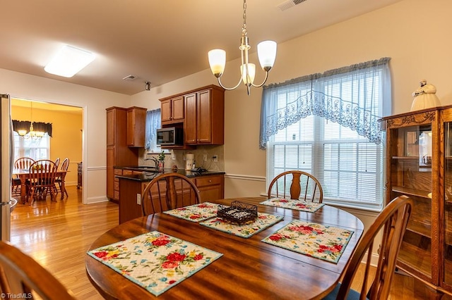 4036 Eastside Ct, Winston-Salem, NC 27127 - dining space featuring a chandelier, light wood-style floors, and baseboards