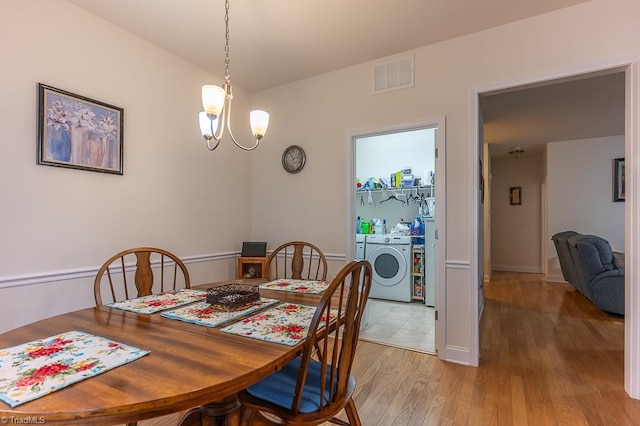 4036 Eastside Ct, Winston-Salem, NC 27127 - dining room featuring a chandelier, washer and dryer, and light wood finished floors