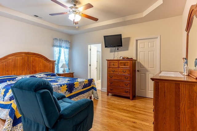 4036 Eastside Ct, Winston-Salem, NC 27127 - bedroom with a raised ceiling, light wood-style flooring, ensuite bath, and ceiling fan