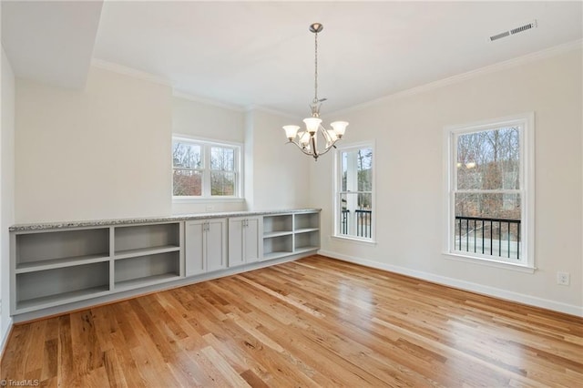 unfurnished dining area featuring visible vents, plenty of natural light, light wood-type flooring, and baseboards