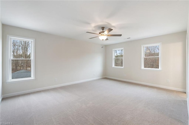 unfurnished room featuring light carpet, visible vents, ceiling fan, and baseboards