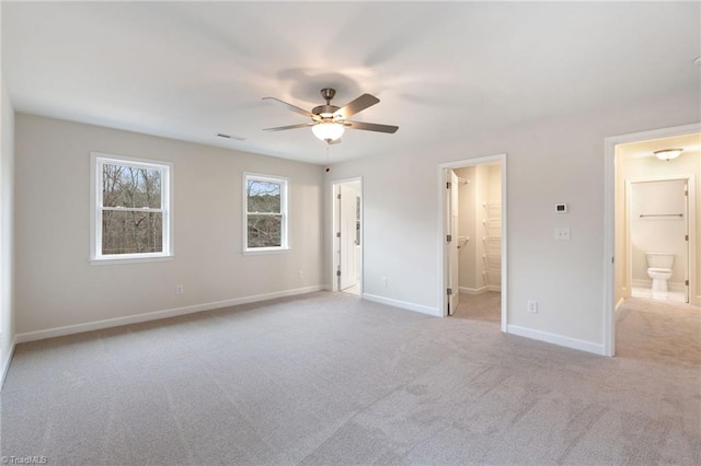 unfurnished bedroom with carpet, baseboards, visible vents, ensuite bath, and ceiling fan